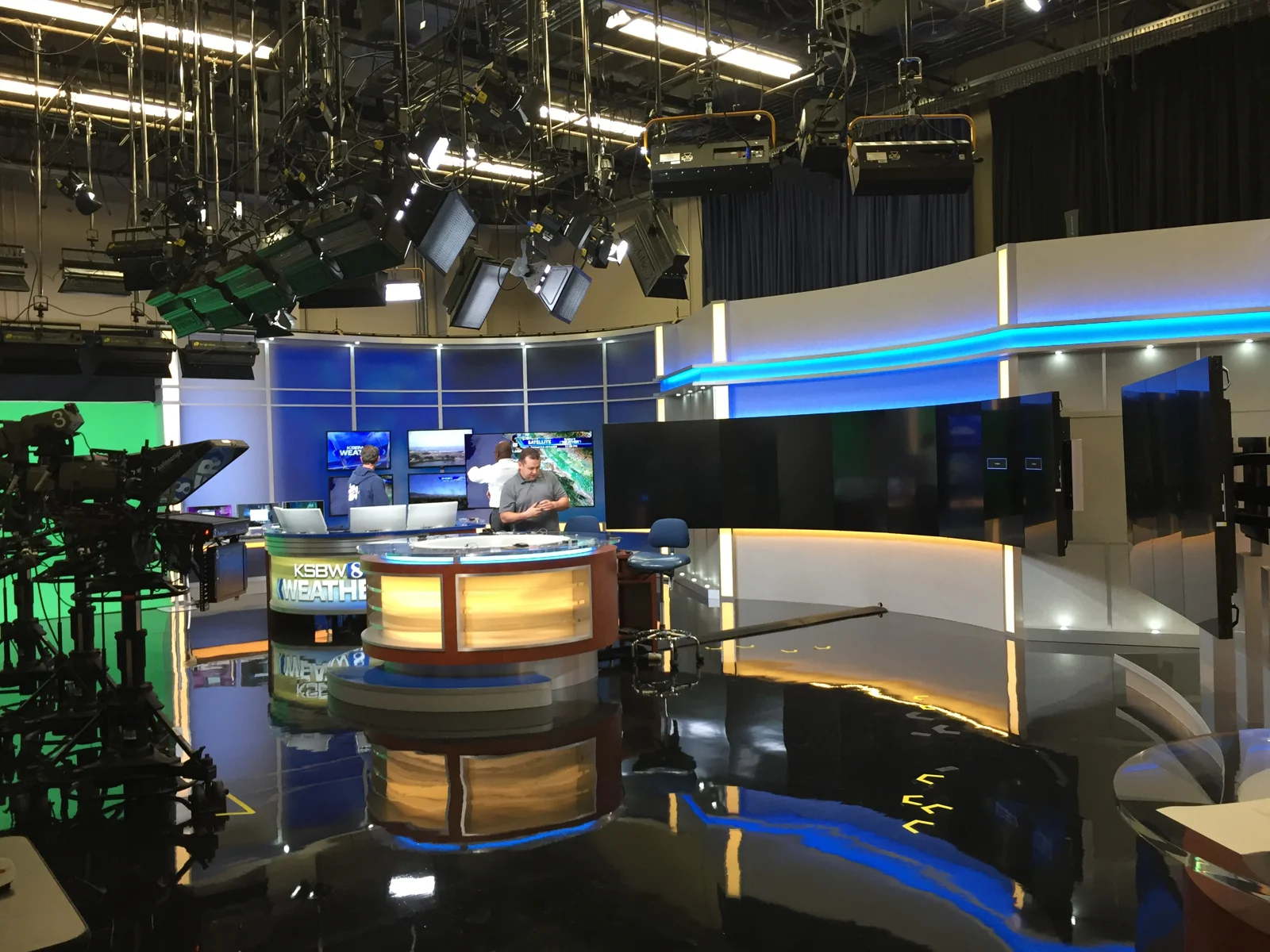 Wide view of the studio, overhead lighting, and illuminated desks
