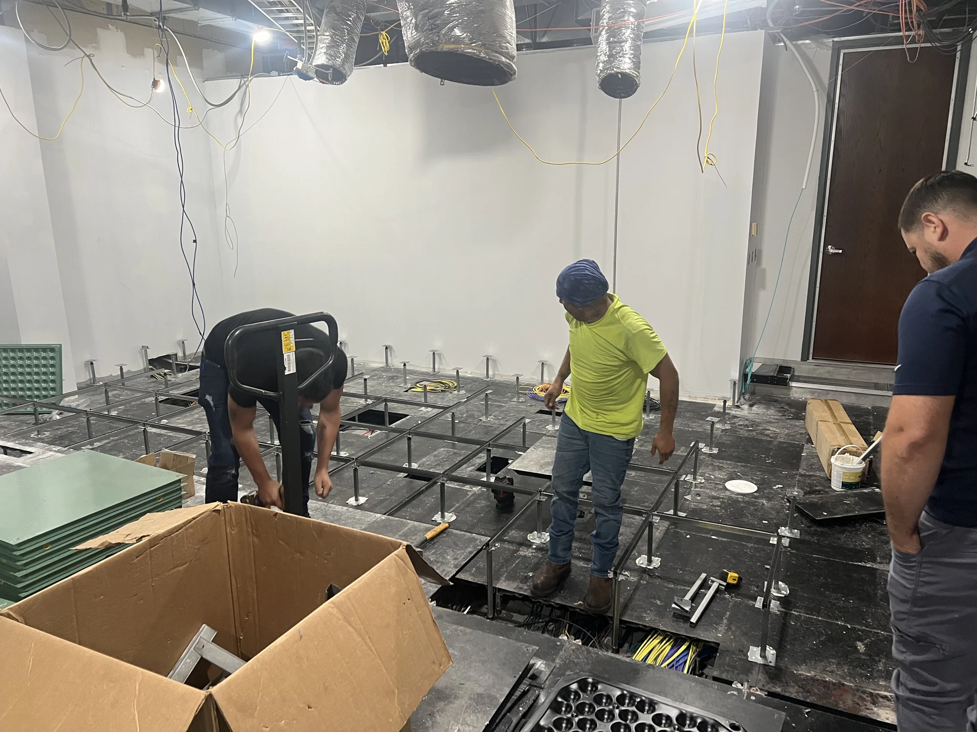 Technicians working on the raised-floor support structure